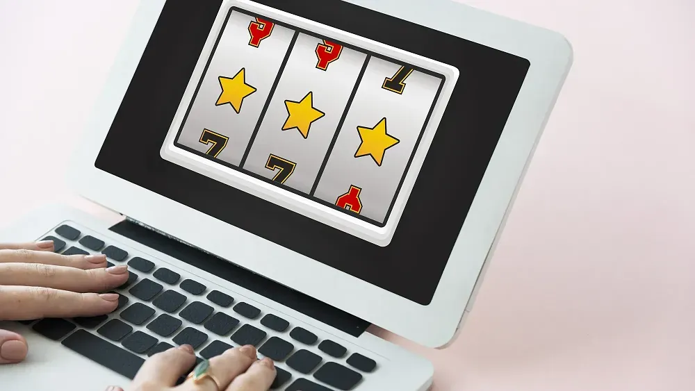 Slot machine showing three stars on a small laptop screen.