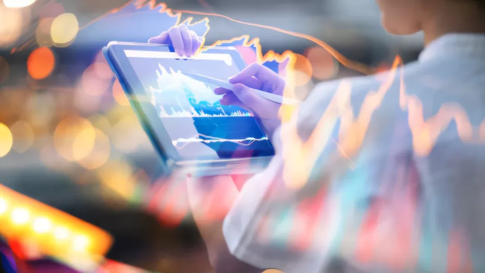 Stylized image of someone looking at what appears to be financial data on a tablet.Source: istockphoto.com.