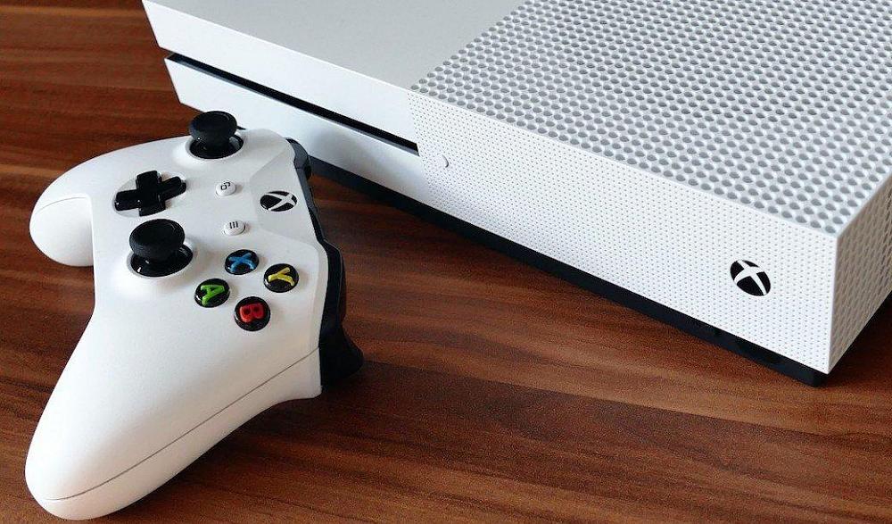 A white, slim Xbox console and white Xbox controller.