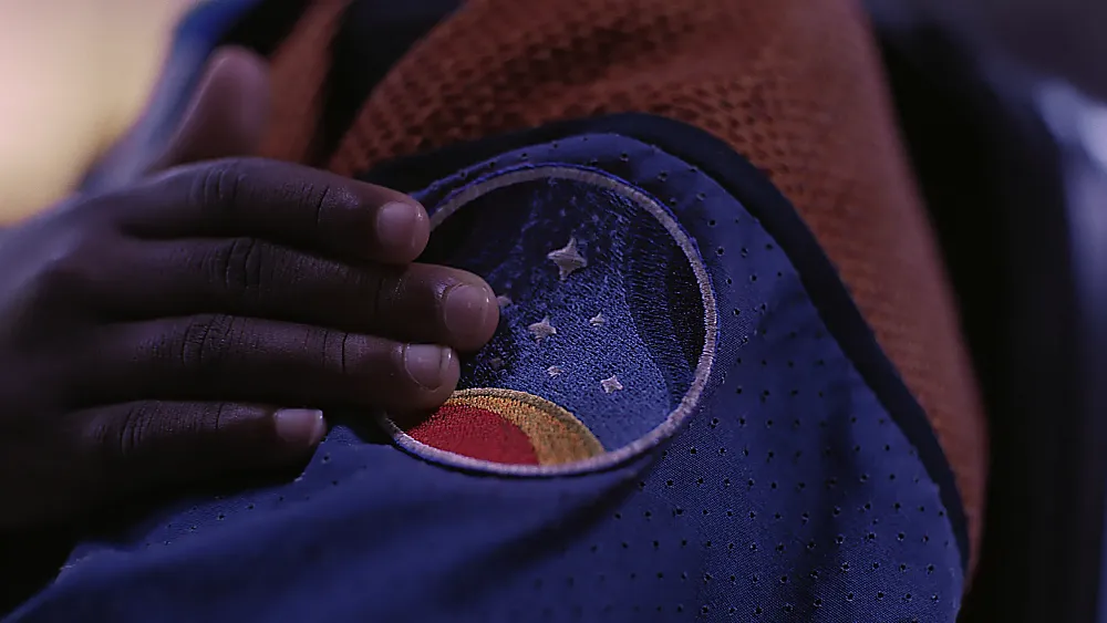 Person holding a space patch to their arm.
