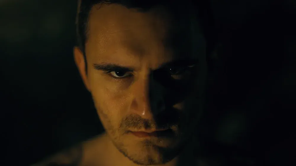 Closeup of a man's face as he stares menacingly at the camera.