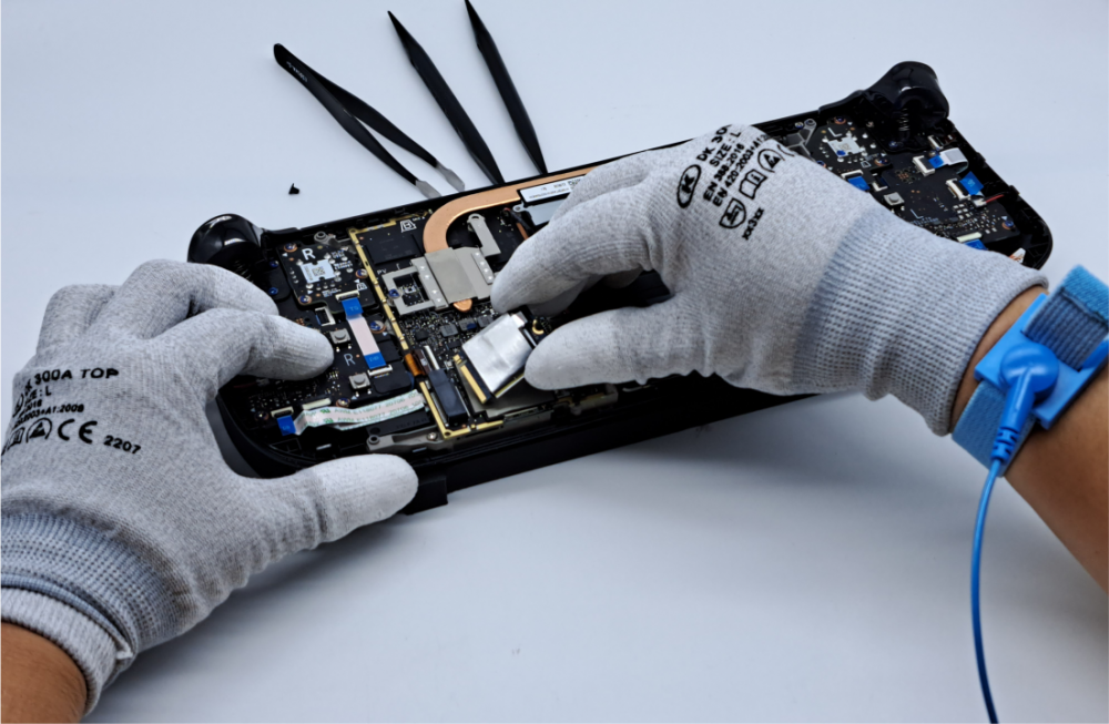 Closeup of a person working to refurbish a piece of hardware called the Steam Deck.