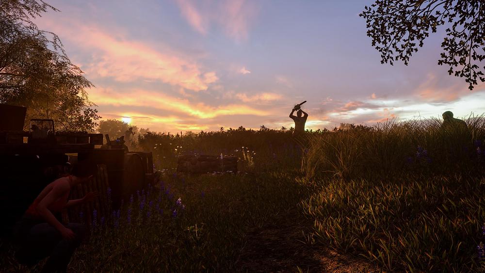 A person holding a chainsaw up in a field on a farm as another character hides in the shadows on the left.