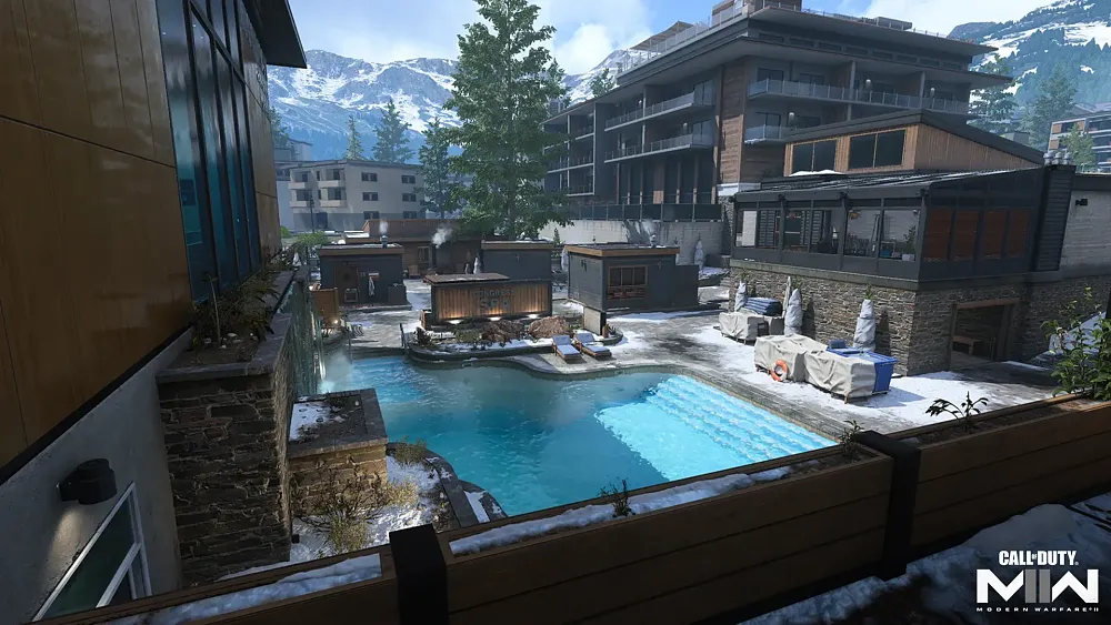 A swimming pool surrounded by several buildings in what looks to be a resort of some kind.