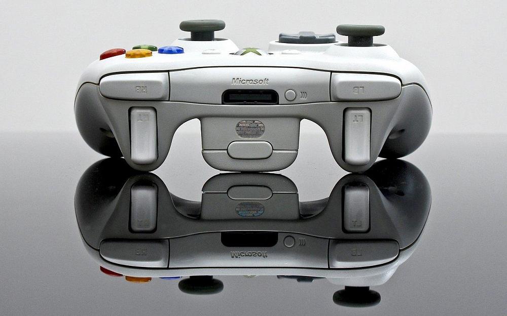 An Xbox 360 controller on a mirrored surface