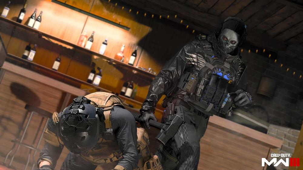 A soldier in a skull mask holding a slegehammer and eyeing another soldier that is on his hands and knees on the ground.