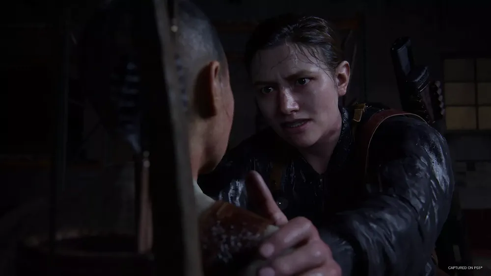 Abby from The Last of Us Part 2 with her hand on the shoulder of another character.