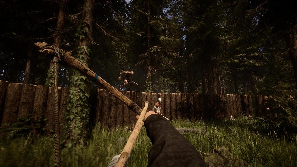 The view of someone aiming a crudely made bow and arrow at enemies. The environment is that of a dense forest area with a manmade wall made of tree trunks serving as protection.