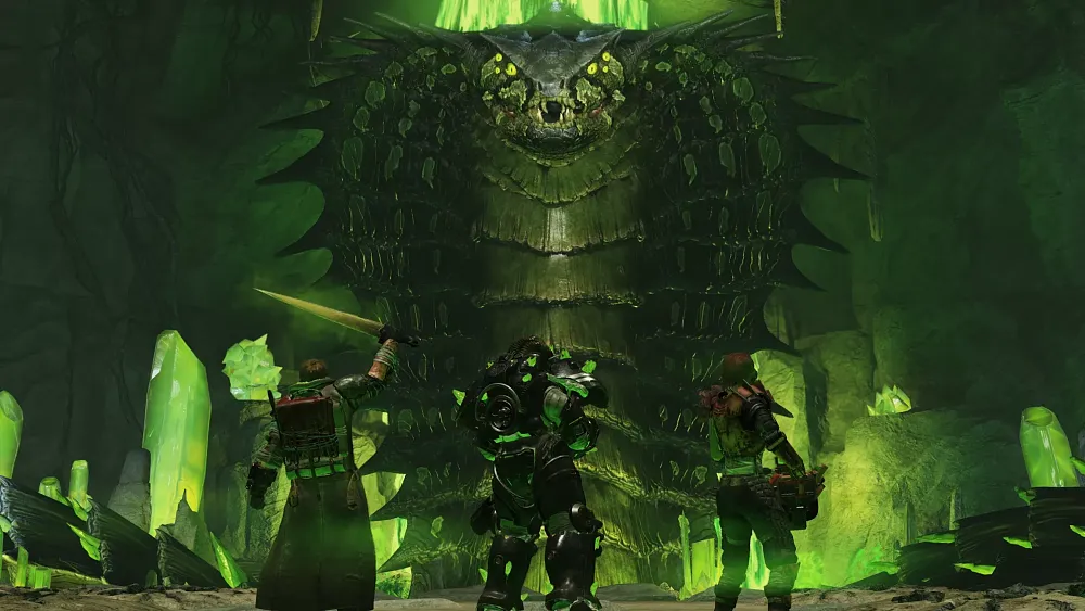 A very green scene showing three players facing off against a multi-story tall evil mutated snake.