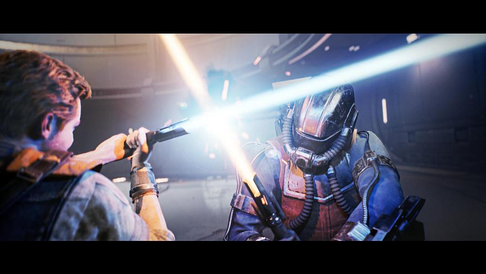 A male with red hair holding a saber made of light clashes against a helmet wearing person also using a saber made of light. Sparks fly where the two sabers meet.