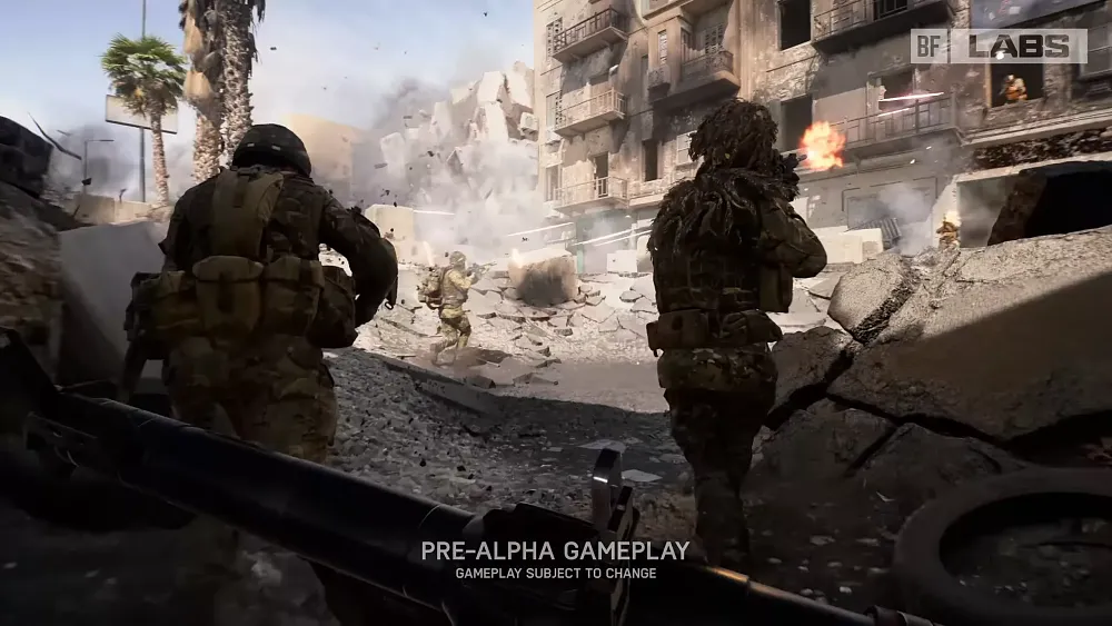 Soldiers running through a war torn middle eastern style city as they are being shot at. A building down the street starts to crumble to rubble. Text at the bottom says: Pre-alpha gameplay. Gameplay subject to change.