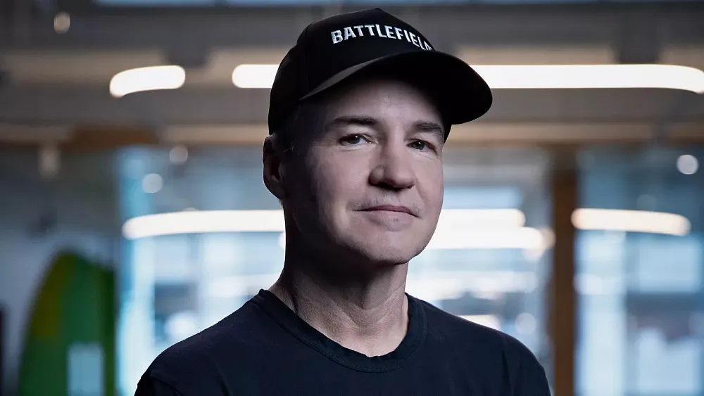 A closeup photograph of a man wearing a "Battlefield" cap. The man is Vince Zampella, founder of Respawn Entertainment and previously the founder of Infinity Ward.