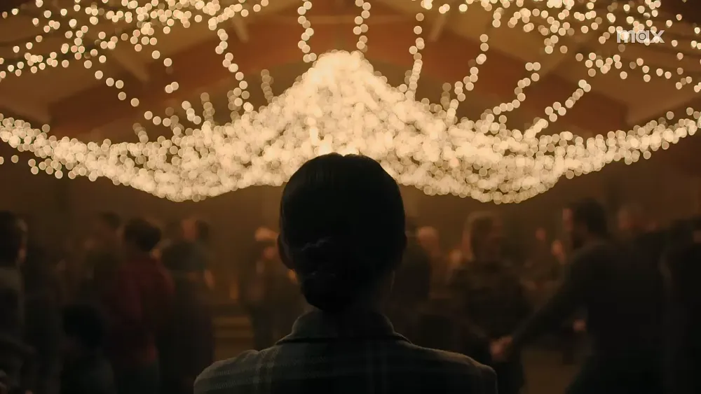 The back of Ellie's head as she's facing a dance decorated with strings of lights.