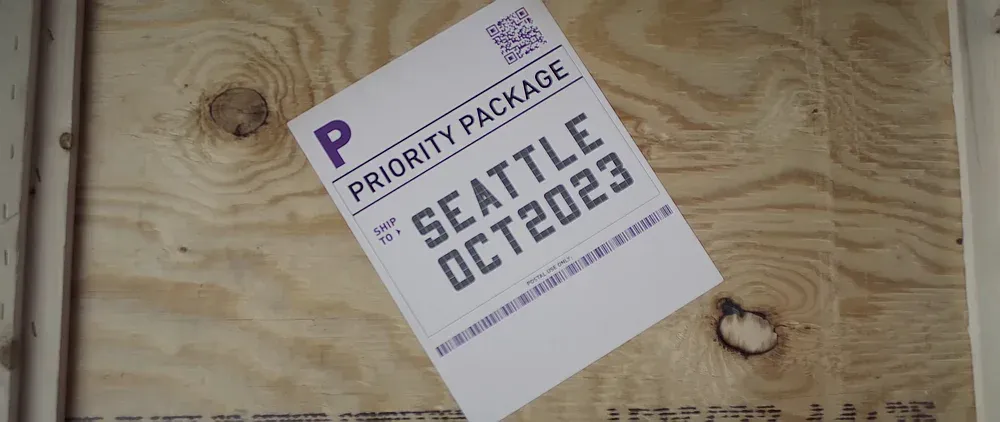 Packing slip on a crate saying Priority Package. Ship to Seattle. October 2023.