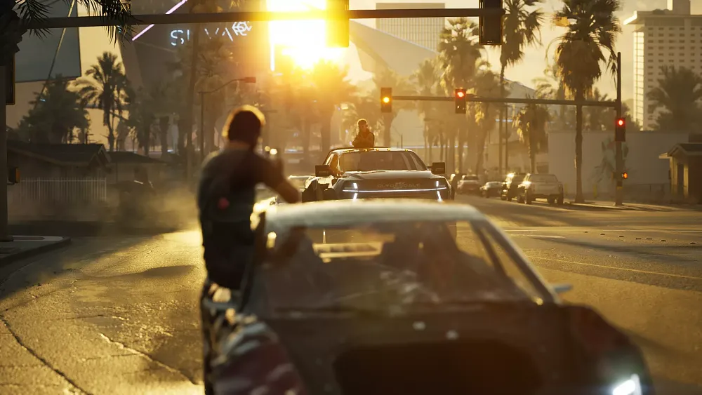 A guy leaning outside of a moving car and shooting back at another car.