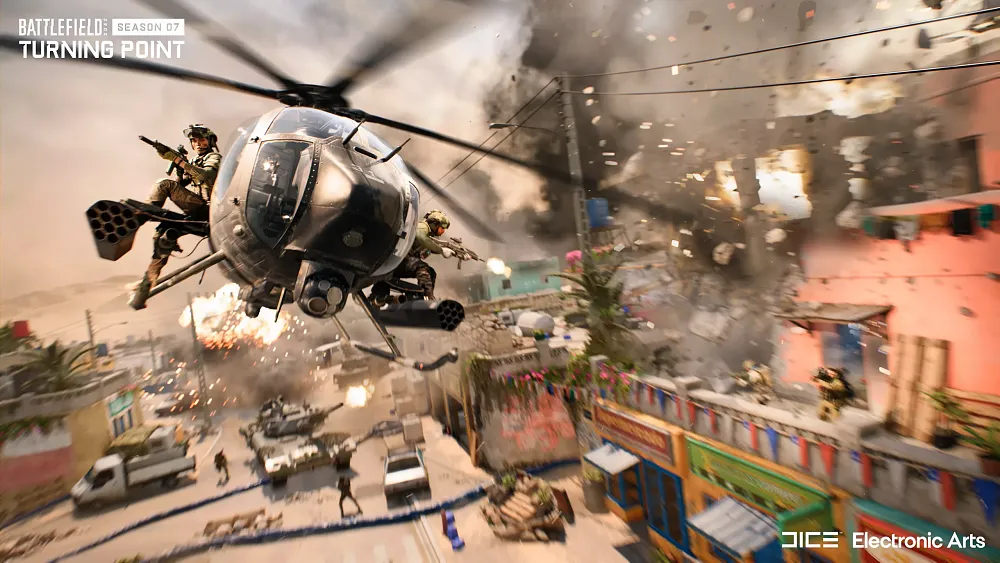 A helicopter flying low over a small city in the middle of a warzone.