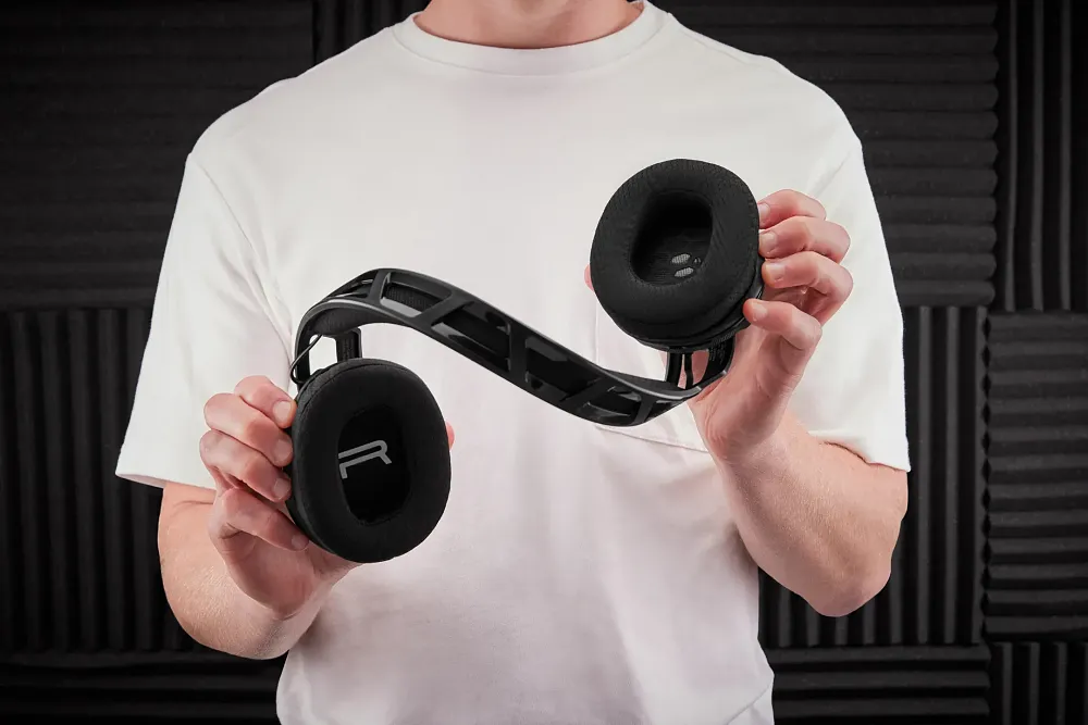 A person twisting a pair of headphones to show their durability