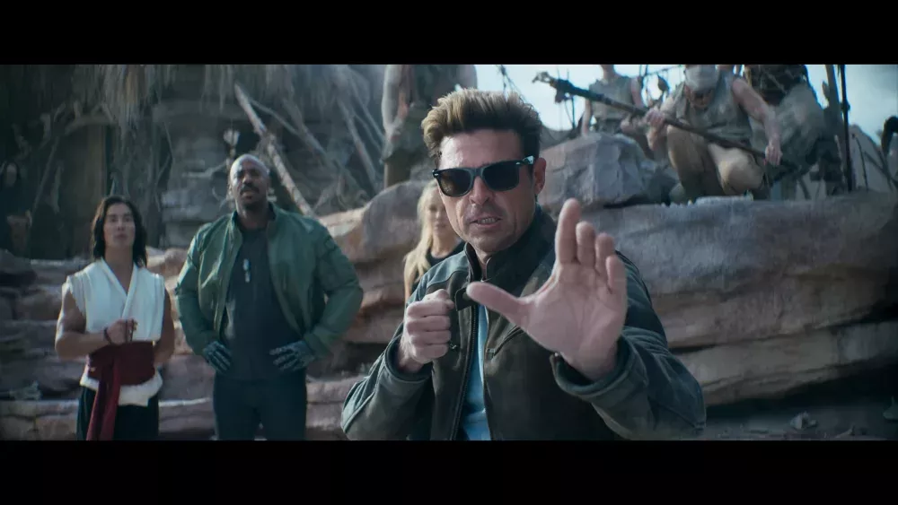 Screen grab from the Mortal Kombat 2 trailer showing Karl Urban as Johnny Cage as other characters from Mortal Kombat look on in the background.