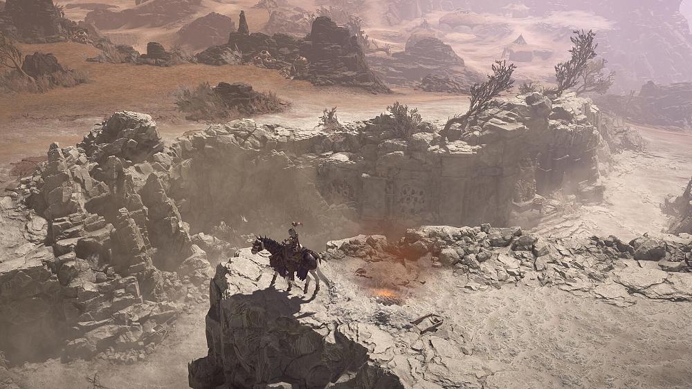 A person sitting on a horse on the edge of a canyon ridge.