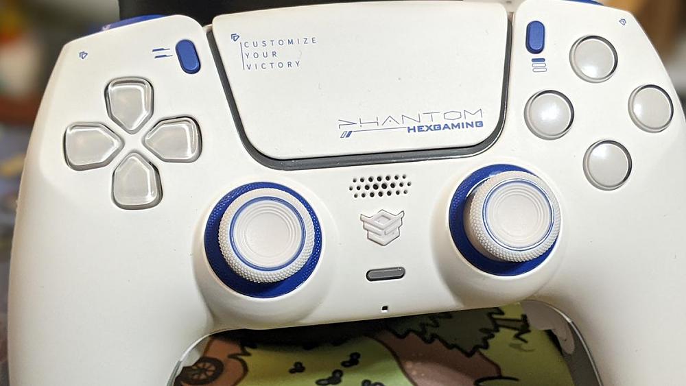 Photo of the HexGaming Phantom controller with HEX Hall Effect Sticks. It's a pure white DualSense styled controller with blue accents.