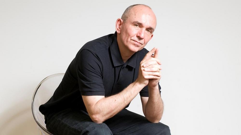 Mostly bald guy sitting smugly.