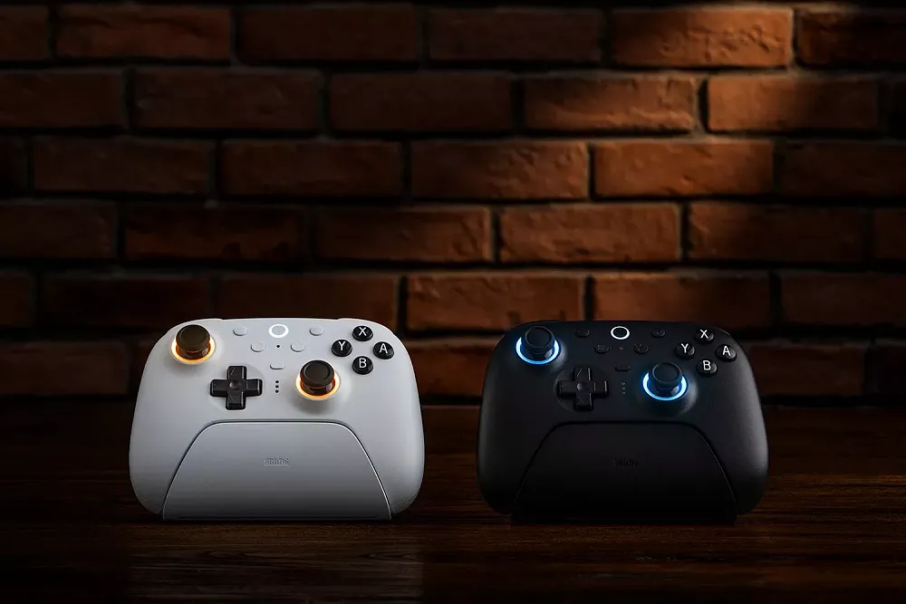 Two 8BitDo controllers on their charging docks.