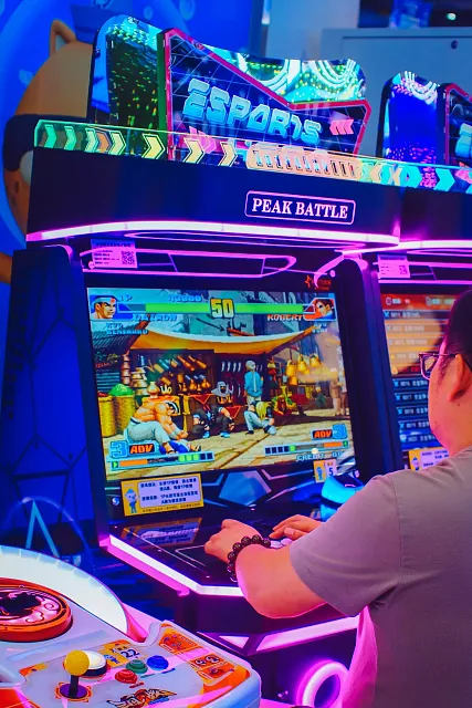 A person playing a fighting game at an arcade. Image via pexels.com.