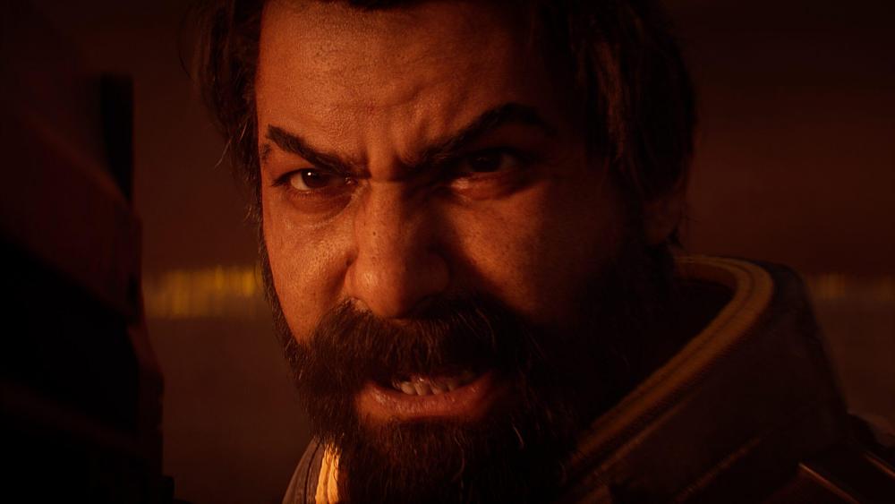 A closeup of the face of an angry bearded man. It's a digital version of actor Rahul Kohli from the game Saros.