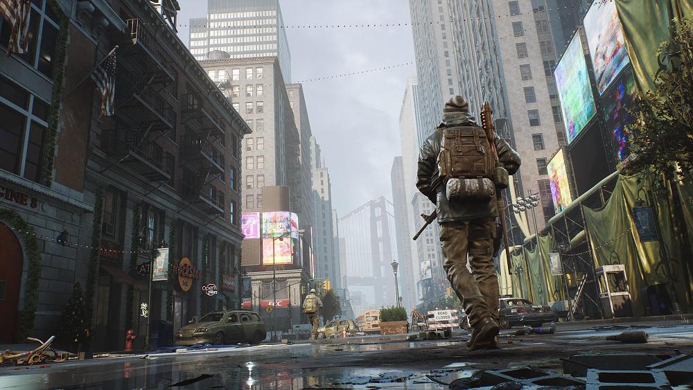 A man wearing layers of clothing and a backpack walking through abandoned streets in a large, major city.