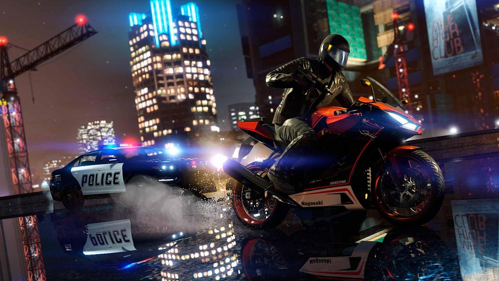 A person on a sports bike with a machine pistol  is trying to speed away from a pursuing police car with its lights on. They are on a wet road covered in a thin layer of water. A blurred cityscape is in the background.