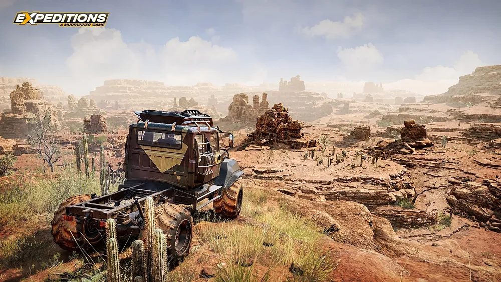 An offroad truck overlooking a vast, rocky landscape.