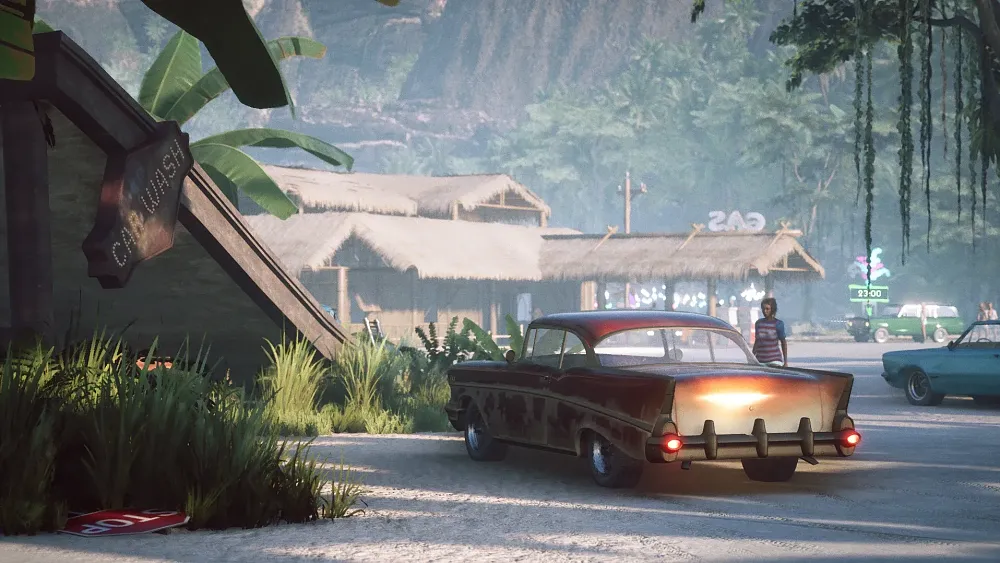 An older model car in a tropical paradise setting.