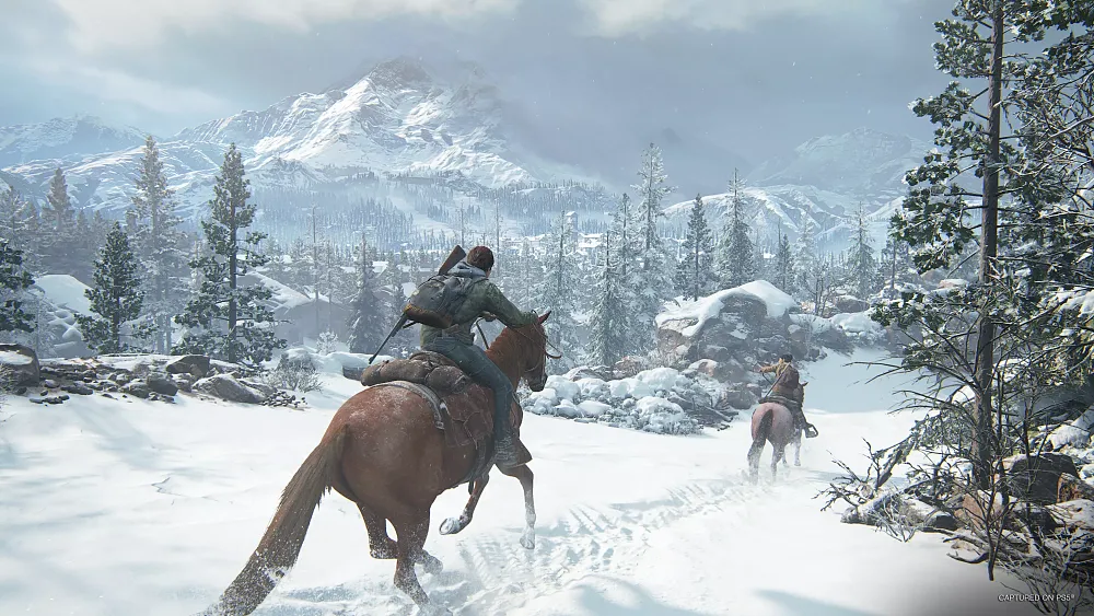 Two people riding horses through a snow covered countryside.