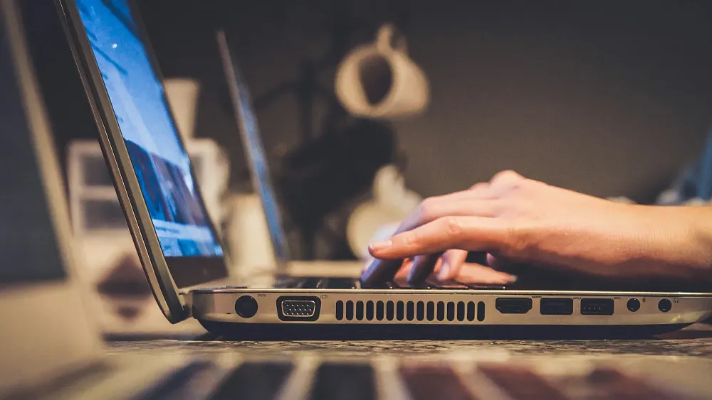 A person browsing the web on their laptop. Photo by John on Unsplash.