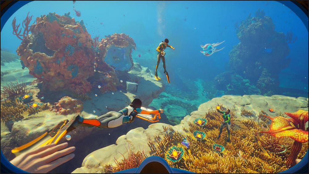 Screenshot showing three divers, from the view of a fourth, exploring reefs and other life underwater.