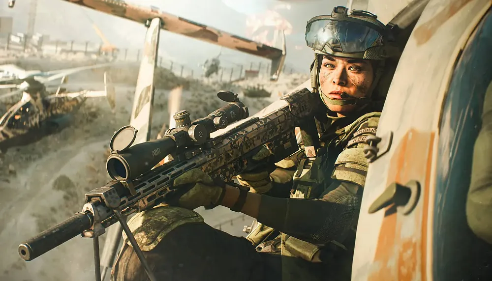 A militar woman leaning out the side of a helicopter holding a large rifle with a scope.