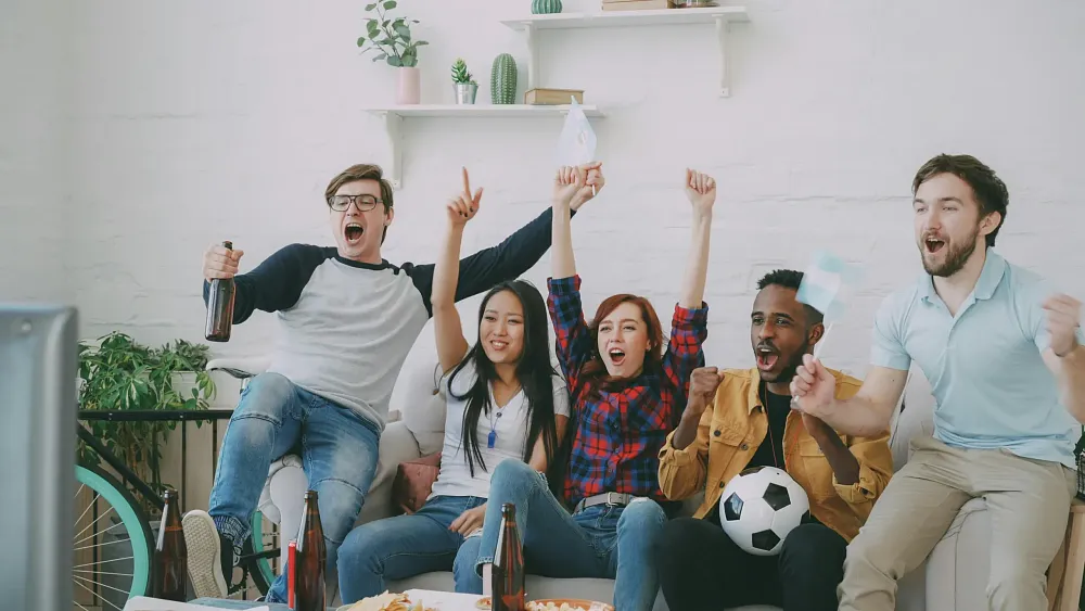 A group celebrating what is presumably a big play during a sporting event. Image from pexels.com.