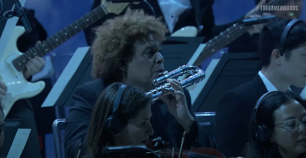 Photo of a man with wild hair excitedly playing a flute