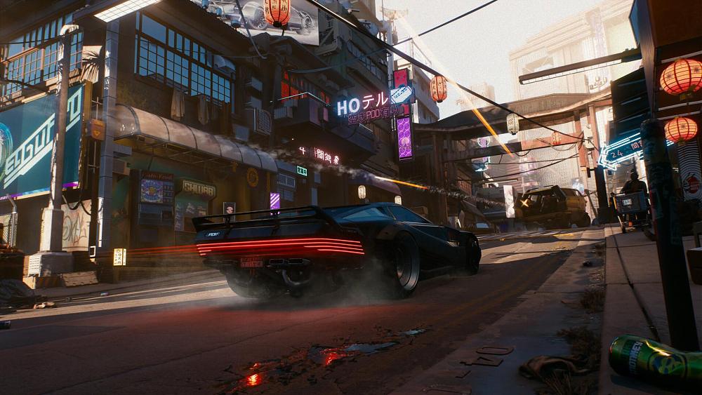 A futuristic black car speeding through a futuristic cyberpunk city. There are neon signs above various shops and litter on the streets. A fan with a couple of enemies up the road is shooting at the approaching black car.