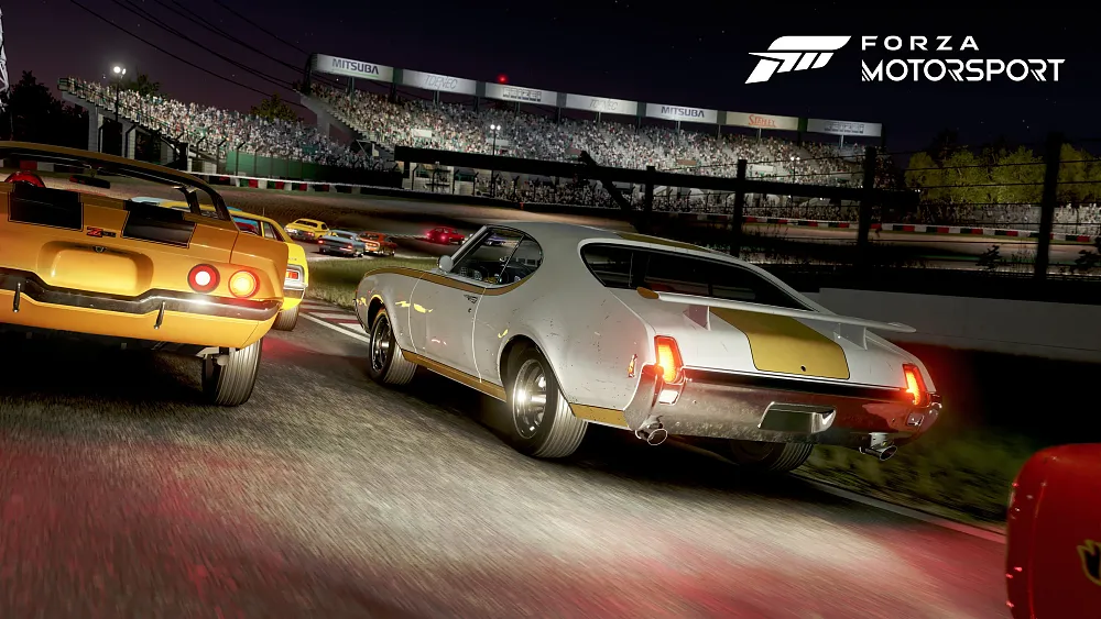 A screenshot from a racing game showing several muscle cars racing around a track at night.