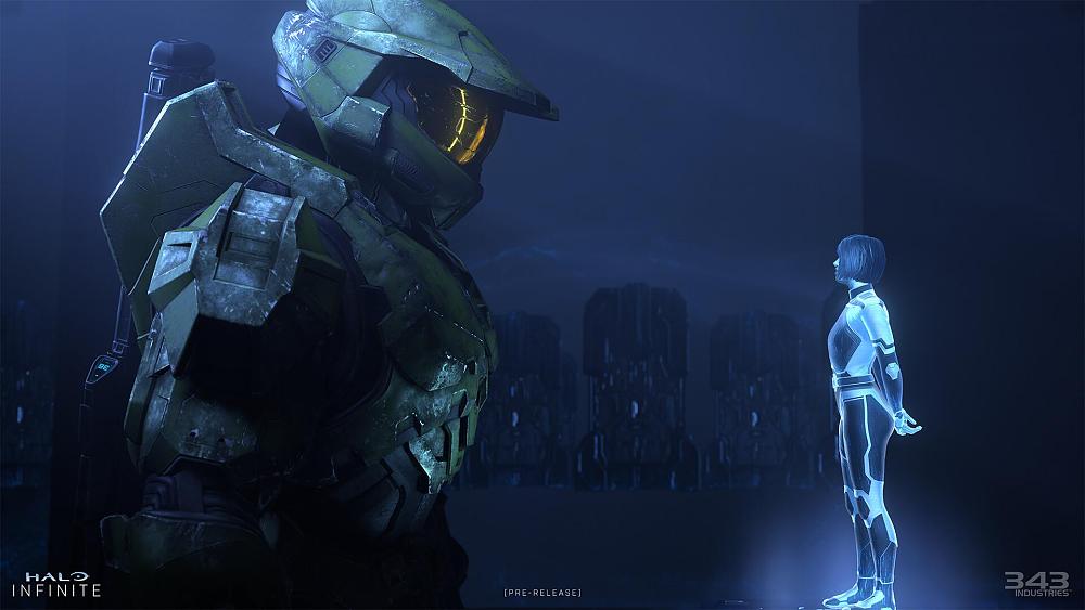 A tall person in heavy green futuristic military armor, wearing a similar green helmet with gold visor, and has a gun strapped to their back is looking at a blue hologram of a woman.