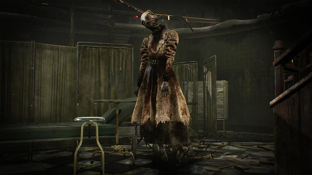 A woman in a bloodied, ragged dress is floating inches above the ground in a makeshift hospital room, a tight sack is wrapped around her head.