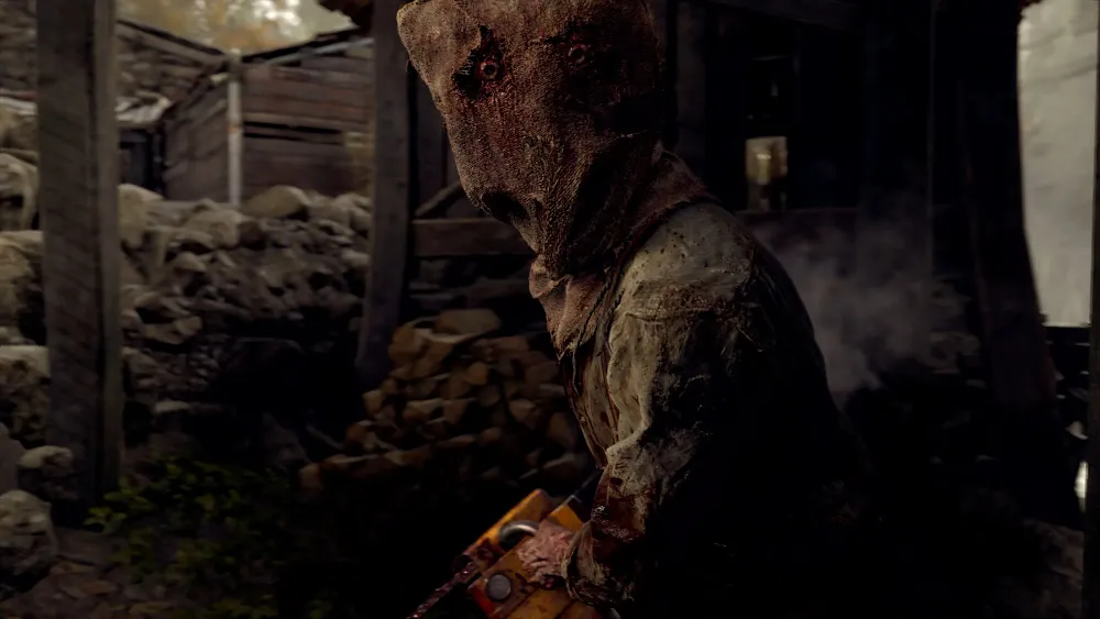 A person with a burlap sack over his face holding a bloody chainsaw.