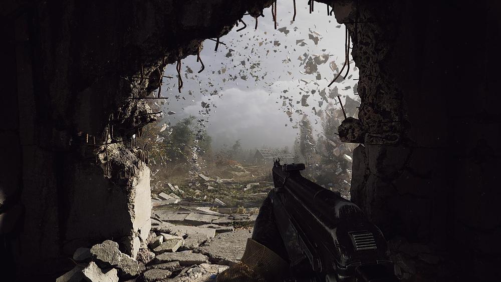 A person holding a gun looking out into a destroyed countryside through a blown out hole in a wall.