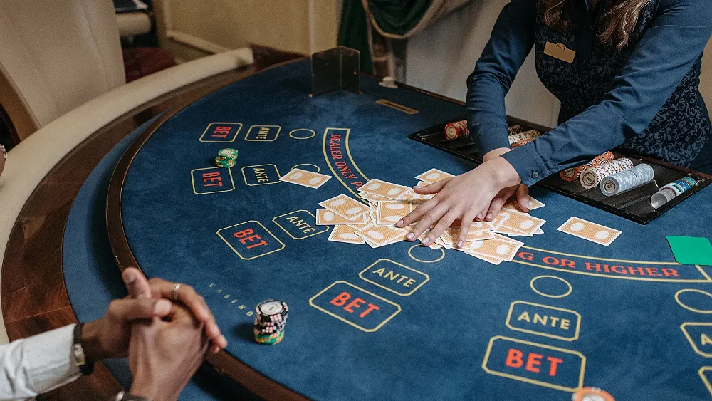 Photo of a casino dealer shuffling cards at a table.