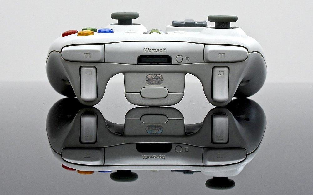 An Xbox 360 controller on a mirrored surface