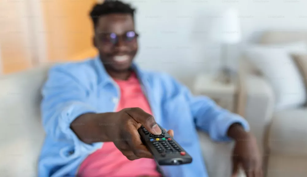 A man holding a TV remote
